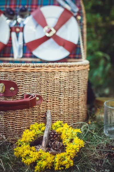 Weinprobe Mosel: Picknickkorb-Detail mit gelbem Blumenkranz und Naturdeko