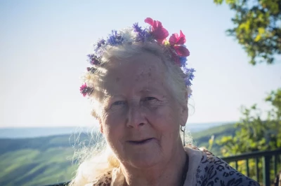 Weinprobe Mosel: Teilnehmerin mit Blumenkranz vor Weinbergs-Panorama, Porträt